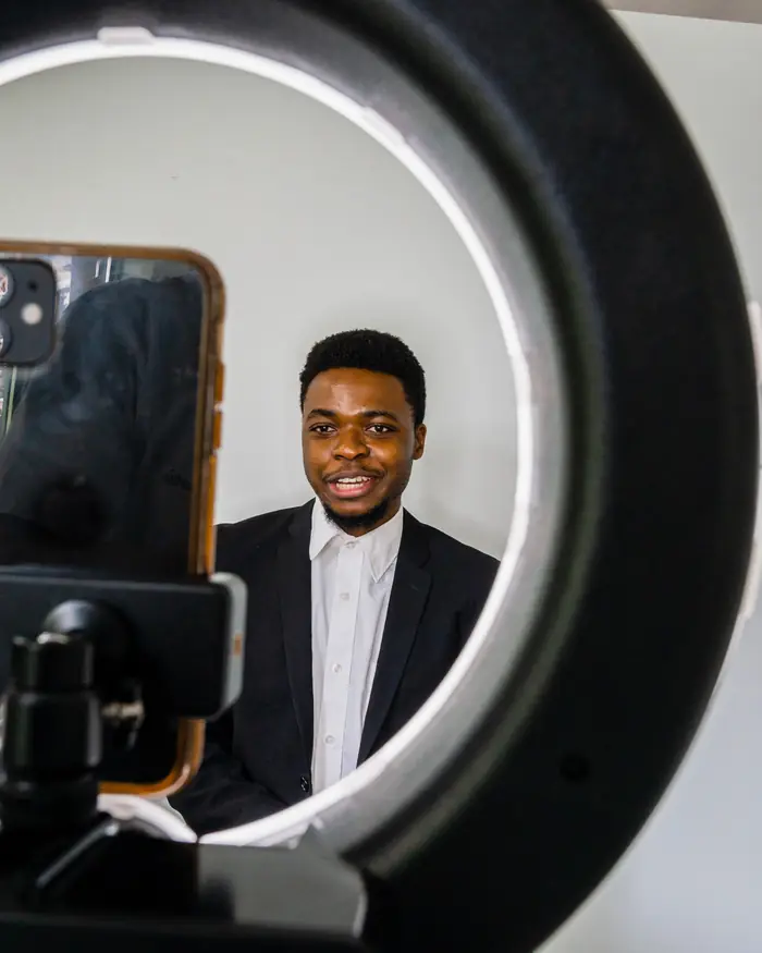 Man recording himself through a ring light